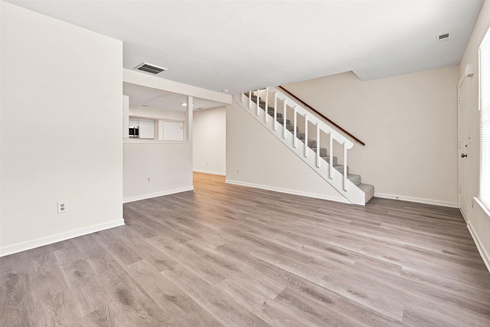 Living room with LVP flooring and stairs to the second floor