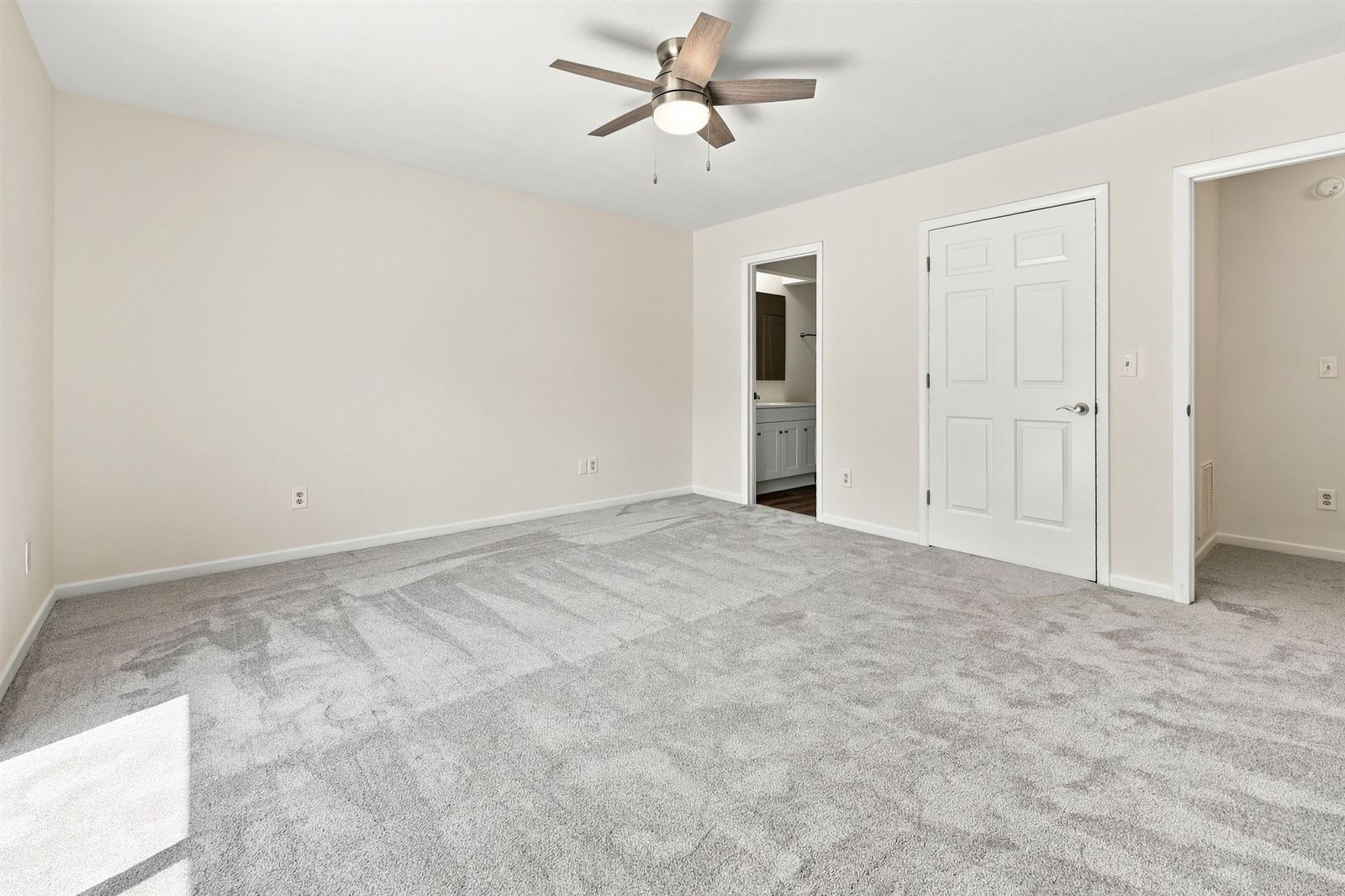 Primary bedroom with ceiling fan and bath access