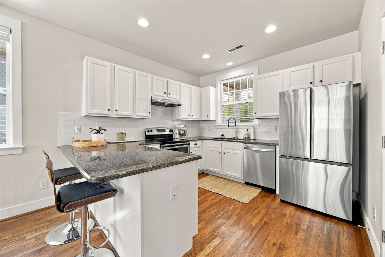 Kitchen with white cabinetry, granite and stainless appliances