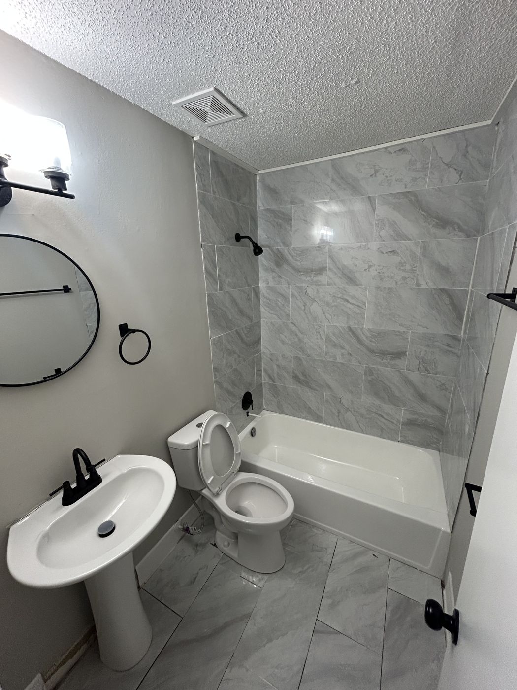 Full bath with tiled tub surround