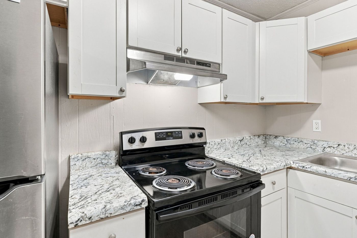 Kitchen with stainless range and white cabinetry